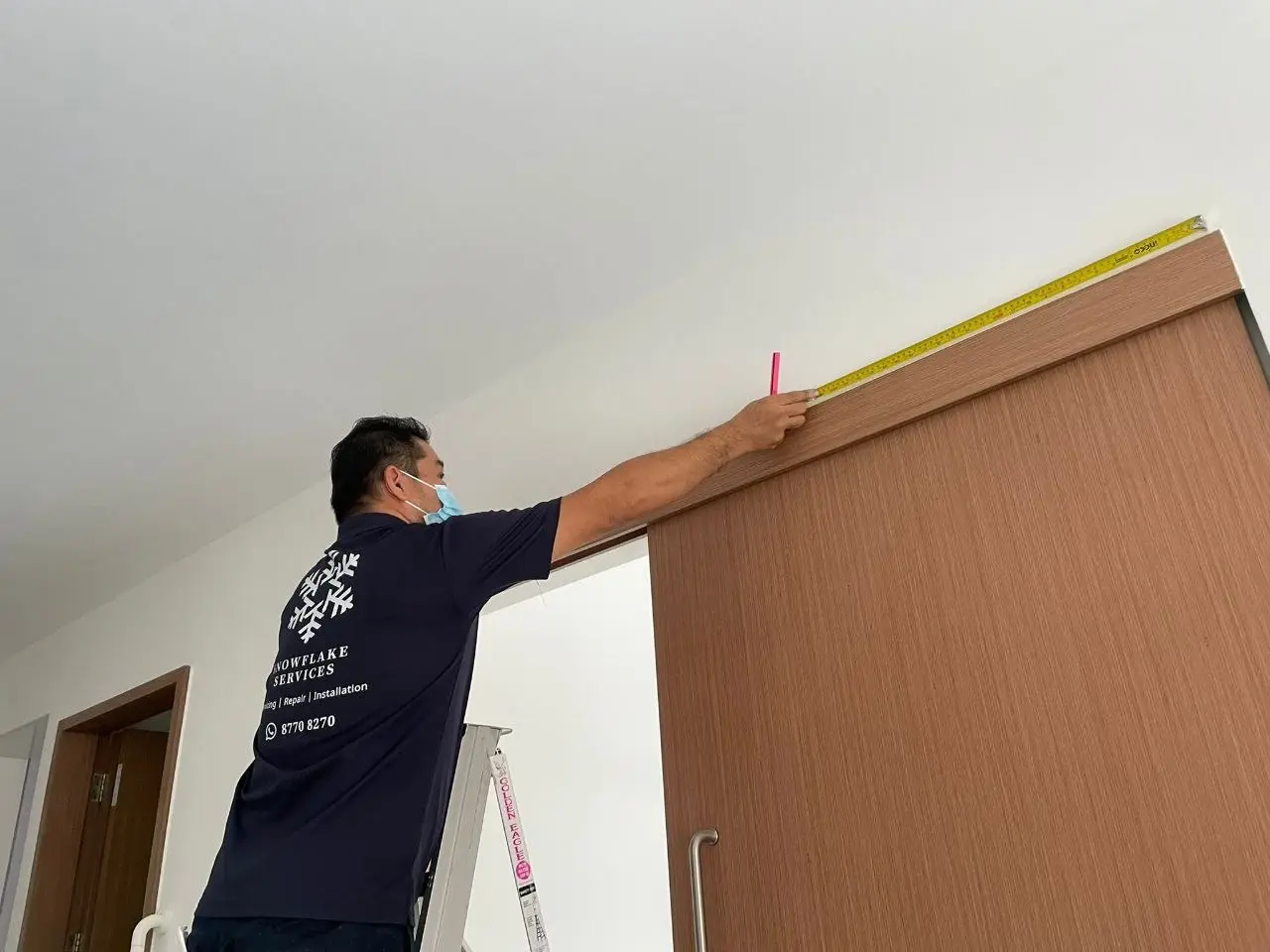 Technician conducting an installation site survey and measuring indoor placement.