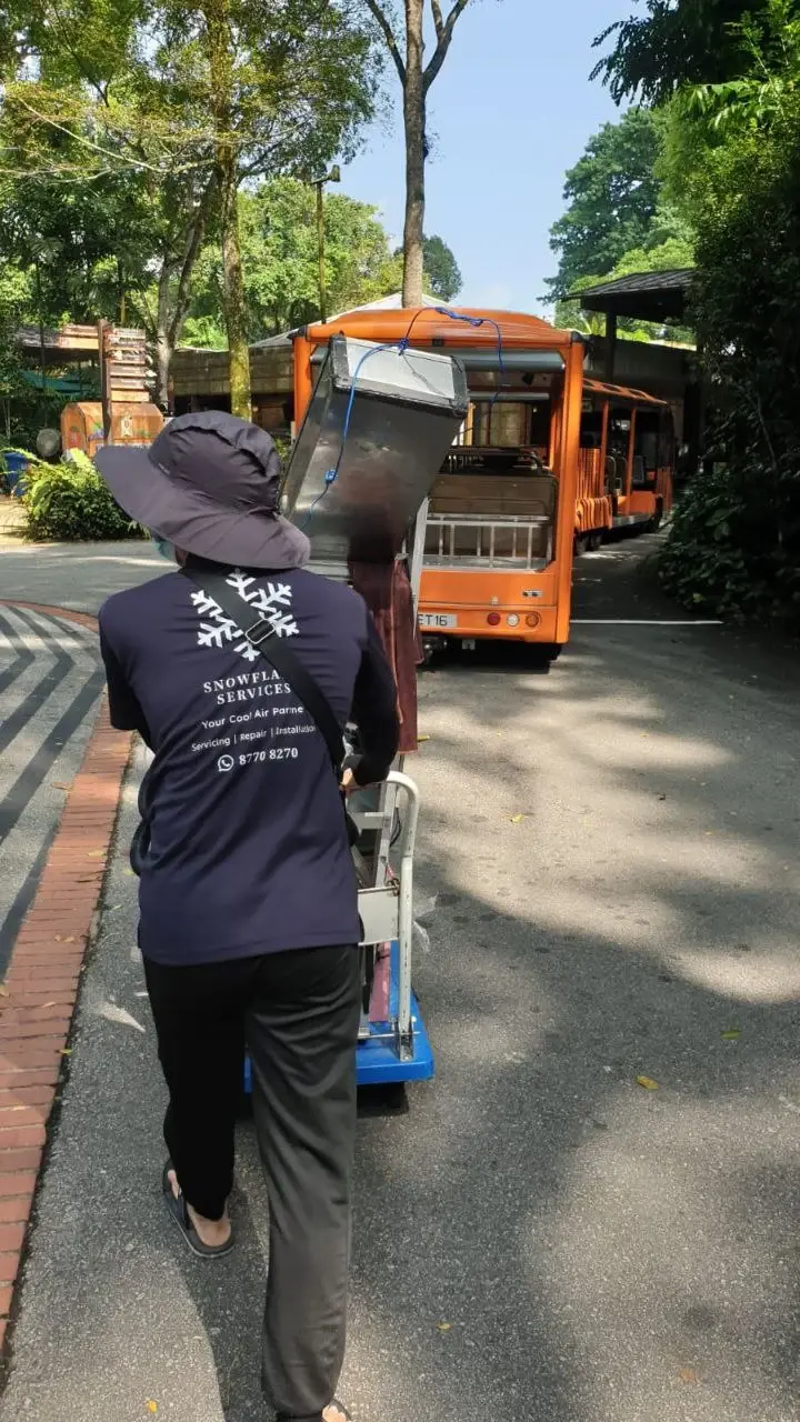 Team member transporting aircon equipment en route to an active work site.